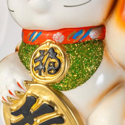 Close-up of the chest decoration on a white Tokoname lucky cat statue