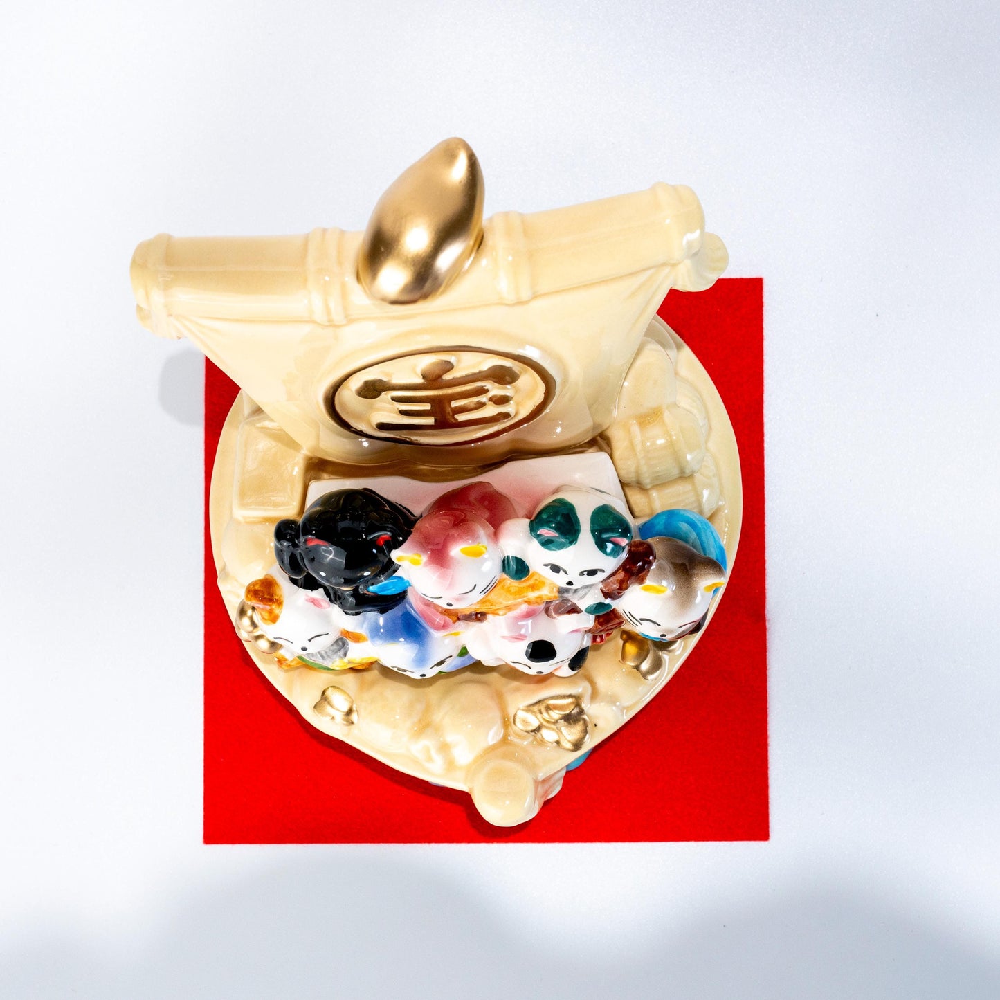 Angled view of ceramic lucky cats aboard a treasure ship