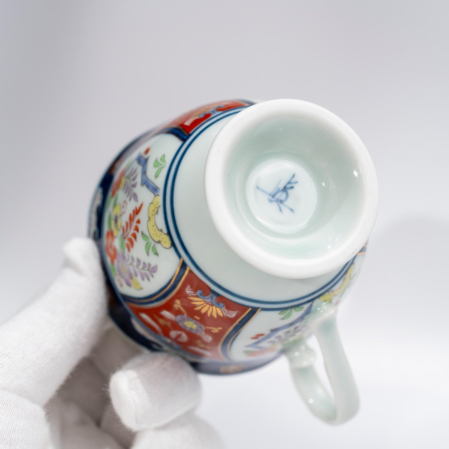Side view of hand-painted porcelain coffee cup with footed base