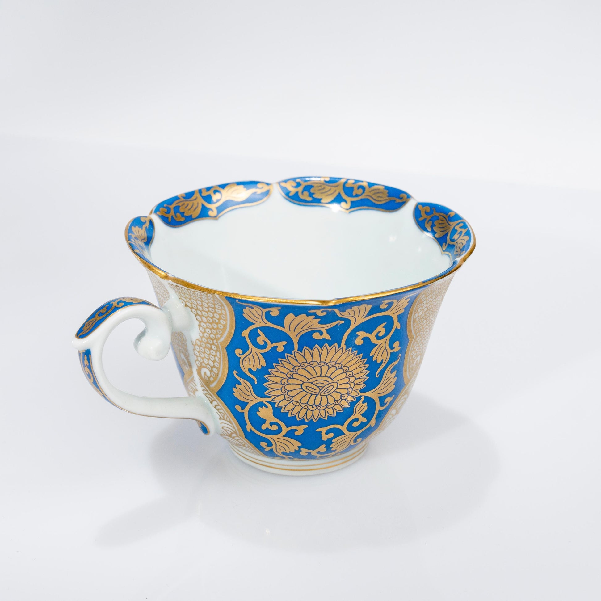 Front view of blue and gold Arita cup and saucer on white background