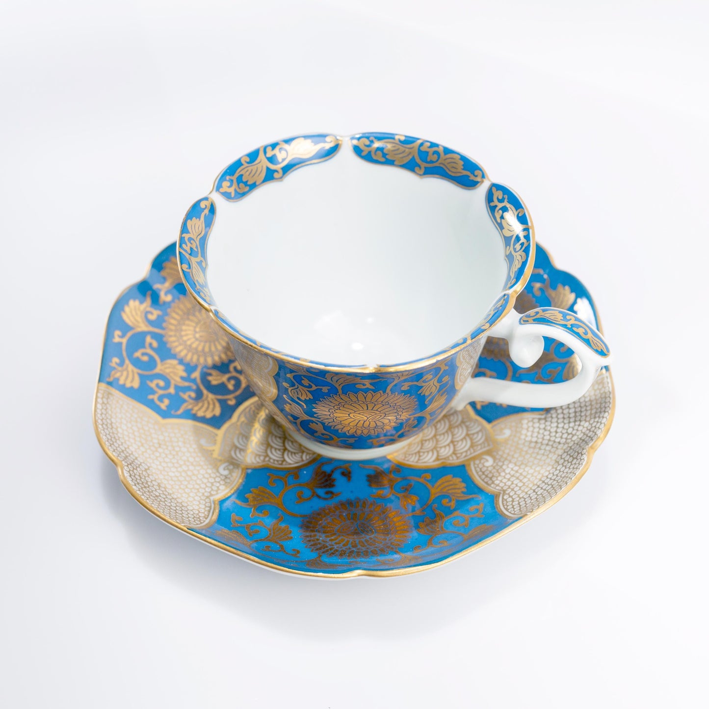 Side view of Arita porcelain cup with blue and gold floral motif