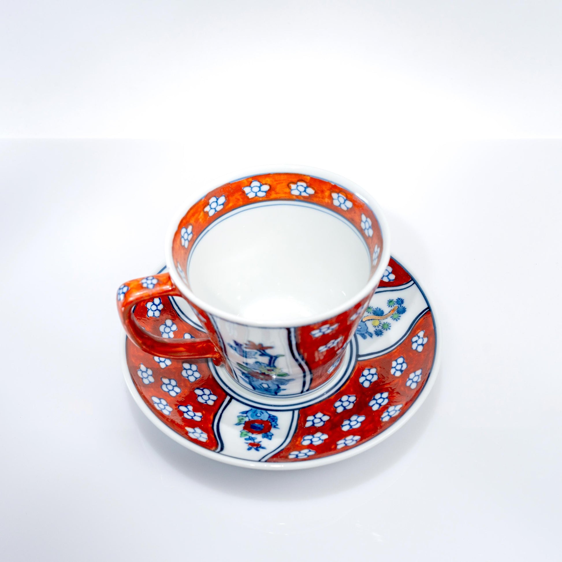 Top view of hand-painted cup and saucer with Four Gentlemen motif
