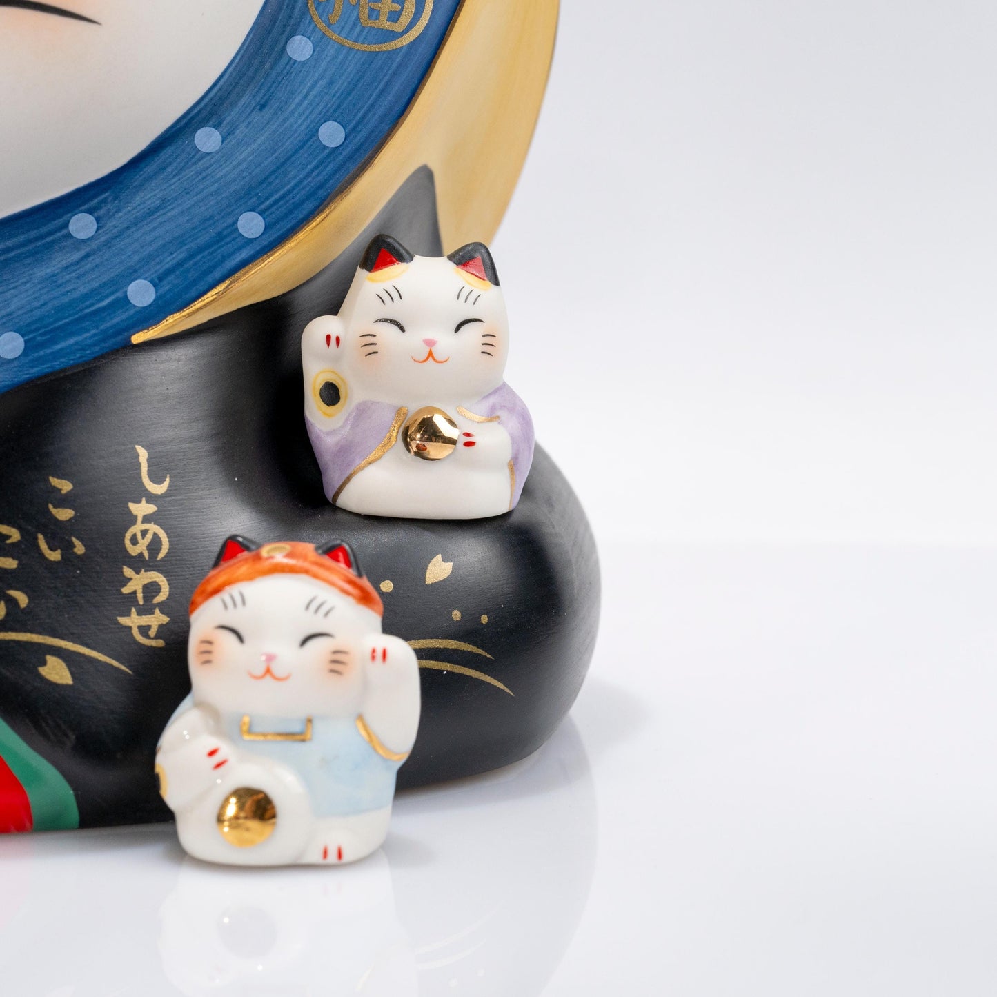 Detail of the Seven Gods of Fortune motif on the lucky cat body