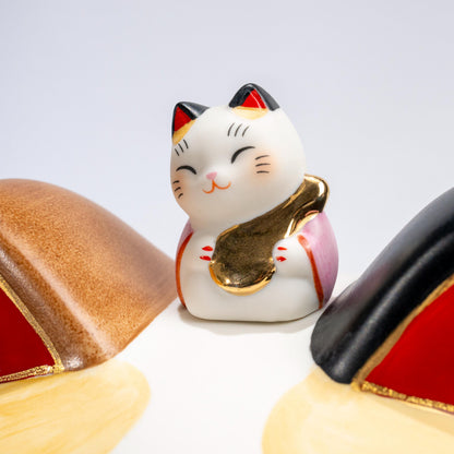 Front view of large ceramic lucky cat piggy bank on red base