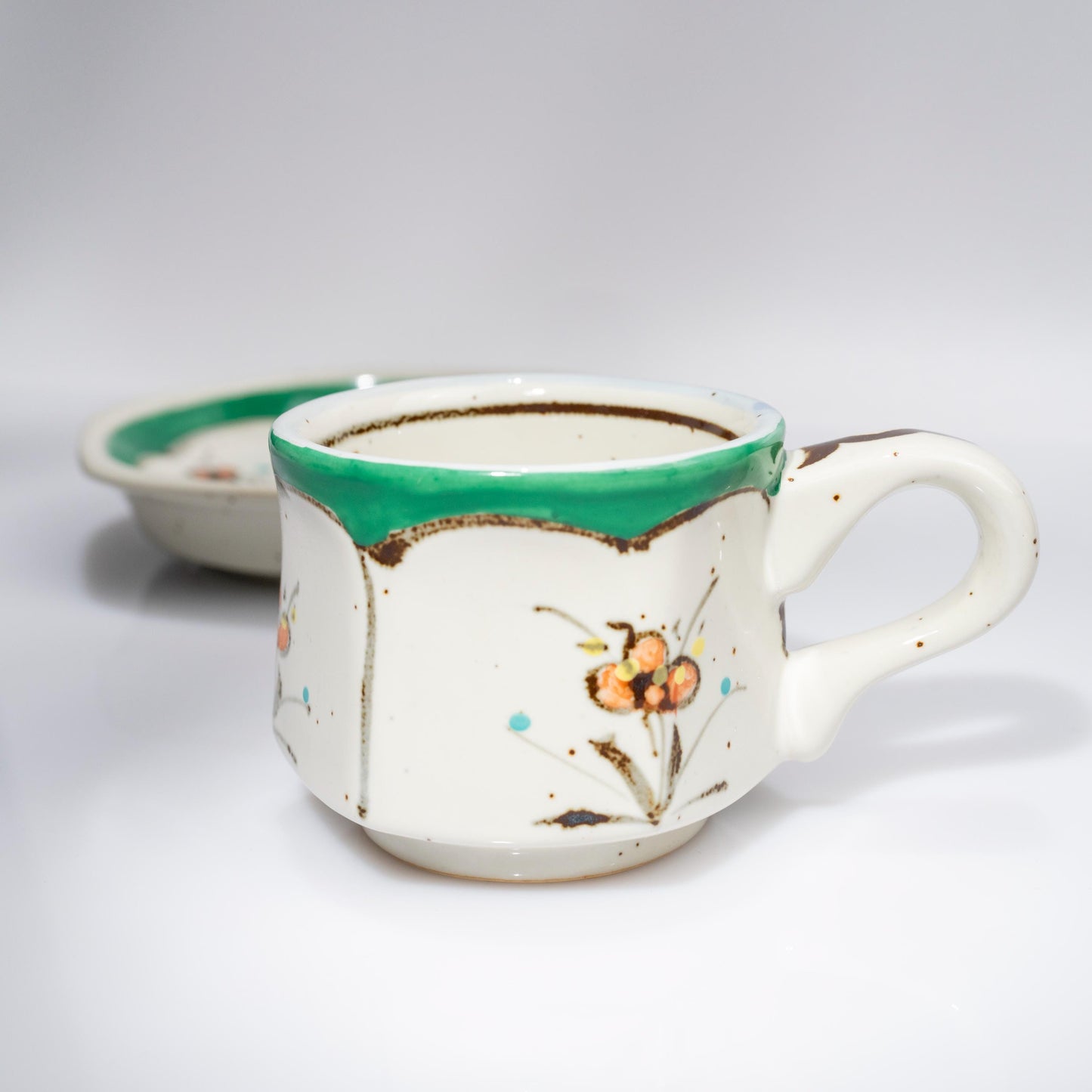 Front view of green floral porcelain demitasse cup and saucer
