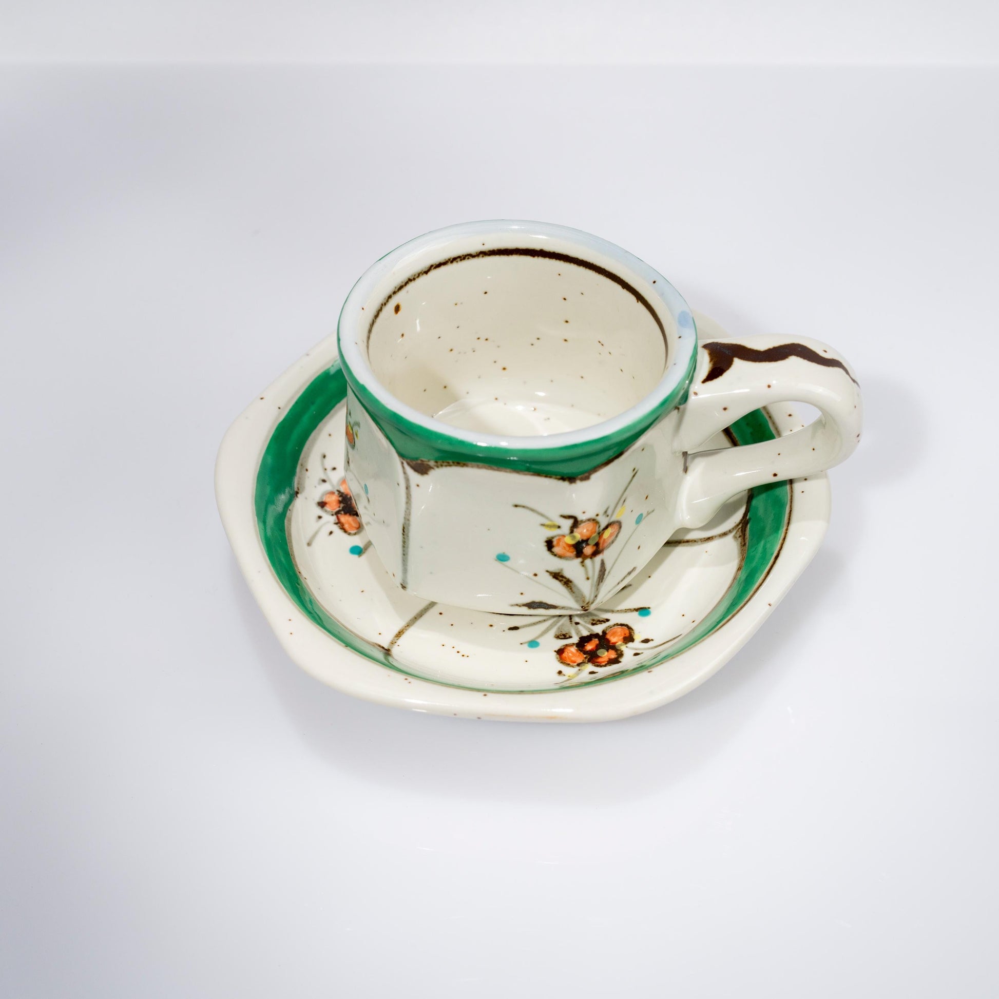 Side view of hand-painted Arita cup with floral motif