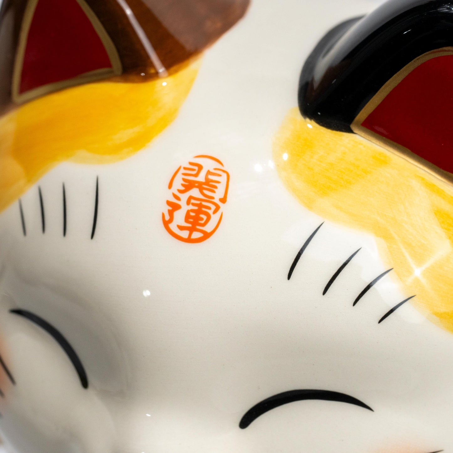 Side detail of painted decoration on lucky cat figurine