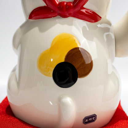 Underside of ceramic lucky cat showing battery compartment