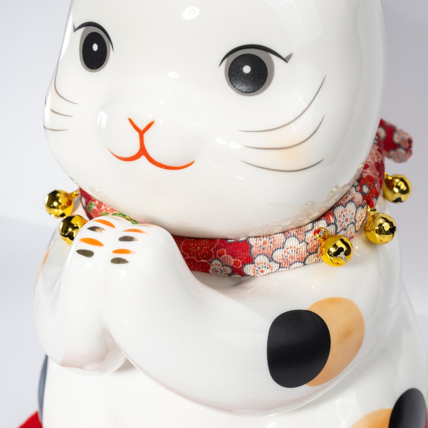 Close-up of painted decoration on maneki neko figurine