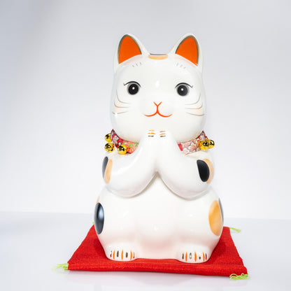 Large Maneki Neko coin bank on red cushion