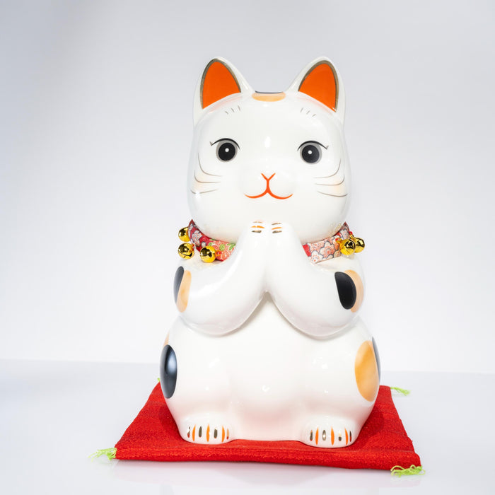 Large Maneki Neko coin bank on red cushion