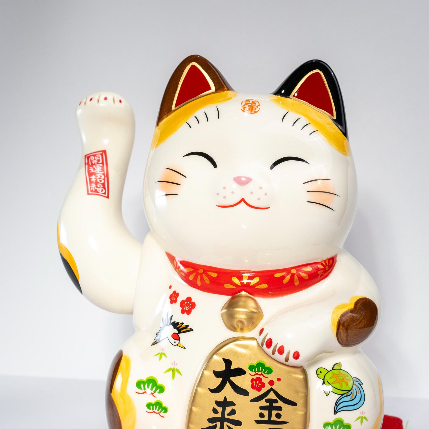 Close-up of smiling face and collar on Maneki Neko