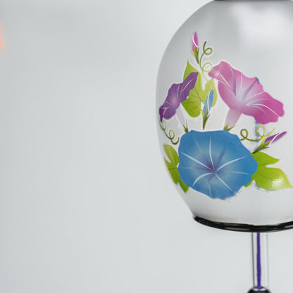 Purple paper tanzaku printed with a flowing-water wave pattern below the glass furin