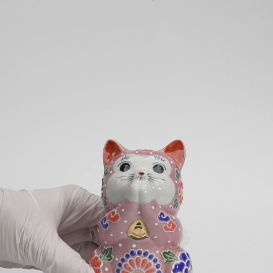 Pink Kutani praying cat with joined paws and raised floral decoration, shown in a 15-second product video.