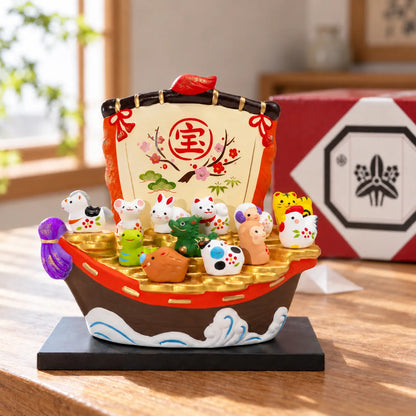 Yakushigama treasure boat with twelve zodiac figures on its black stand beside its red presentation box