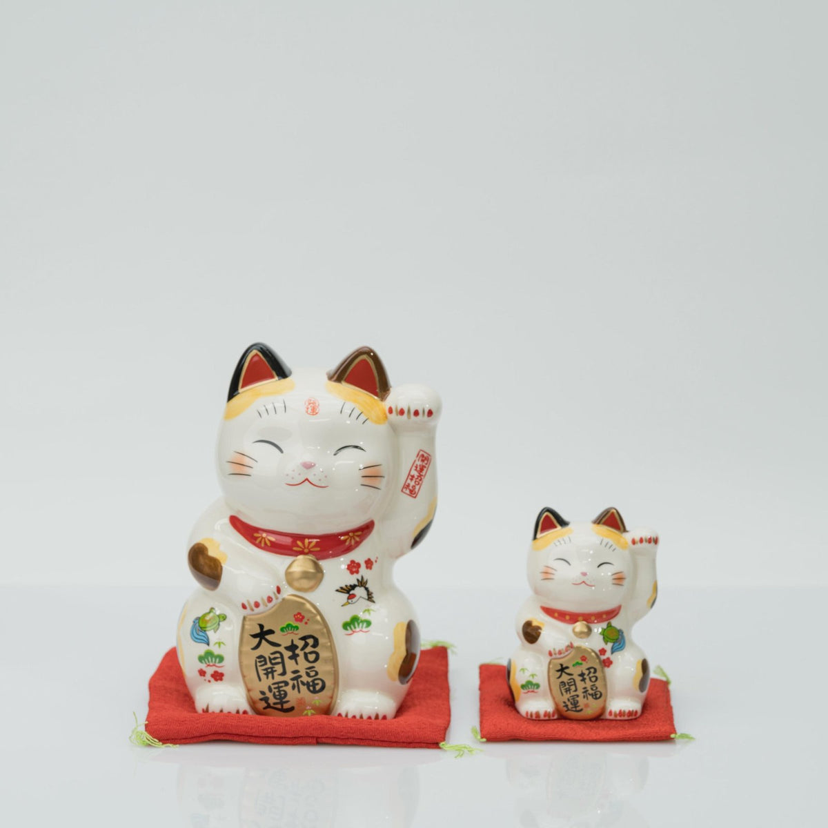 15 cm and 8.5 cm stationary calico lucky cats side by side for size comparison