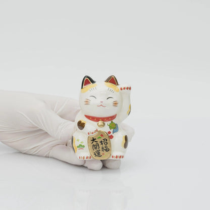 8.5 cm calico lucky cat held in a gloved hand to show its size