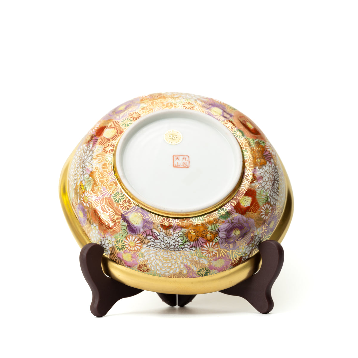 Back of the Kinhanazume serving bowl on a stand, showing floral decoration around a white base with maker's marks.