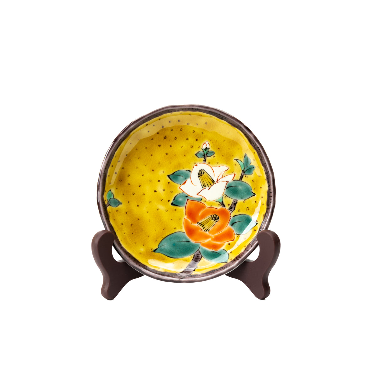 Yellow Kutani camellia plate with orange and white flowers, displayed upright on a dark stand.