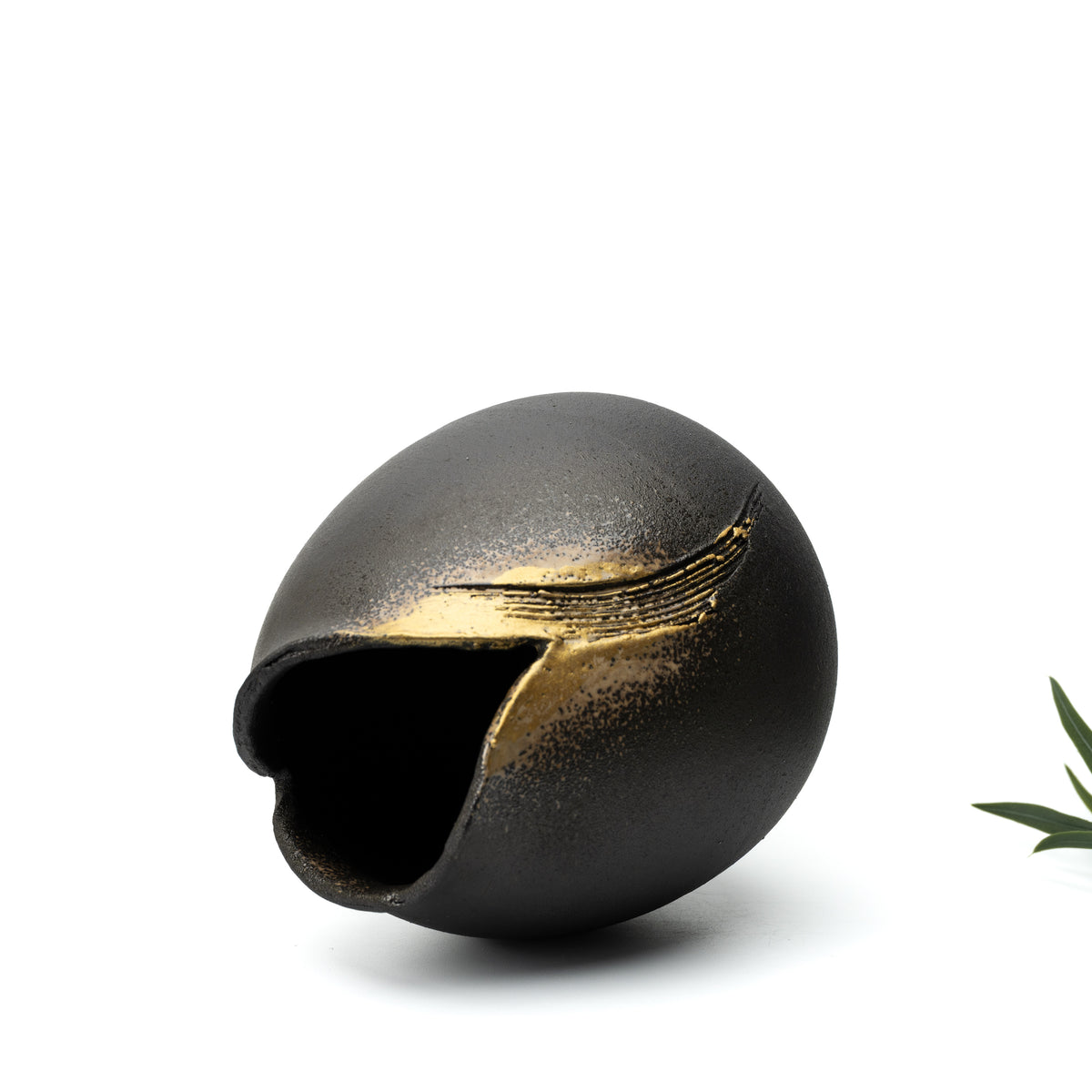 Hechimon Banju vase tilted on its side, showing the dark opening and sweeping gold-colored decoration.