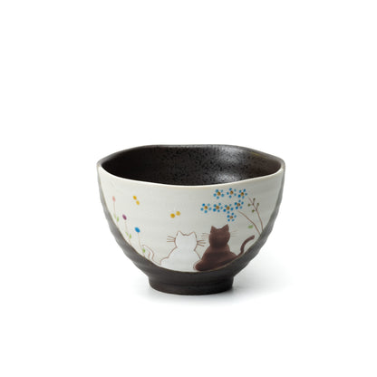 Kutani Hidamari bowl with two cats beneath flowering branches and a dark interior.