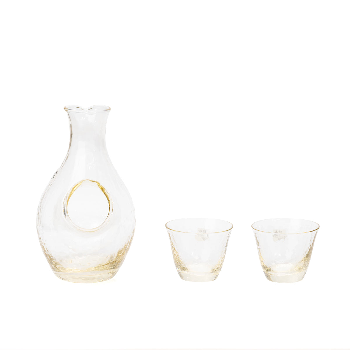 Amber-tinted glass sake carafe with an ice pocket and two matching cups on white.