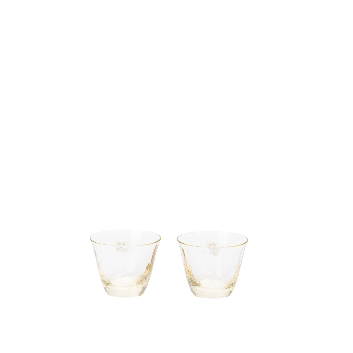 Two amber-tinted glass sake cups on a white surface.