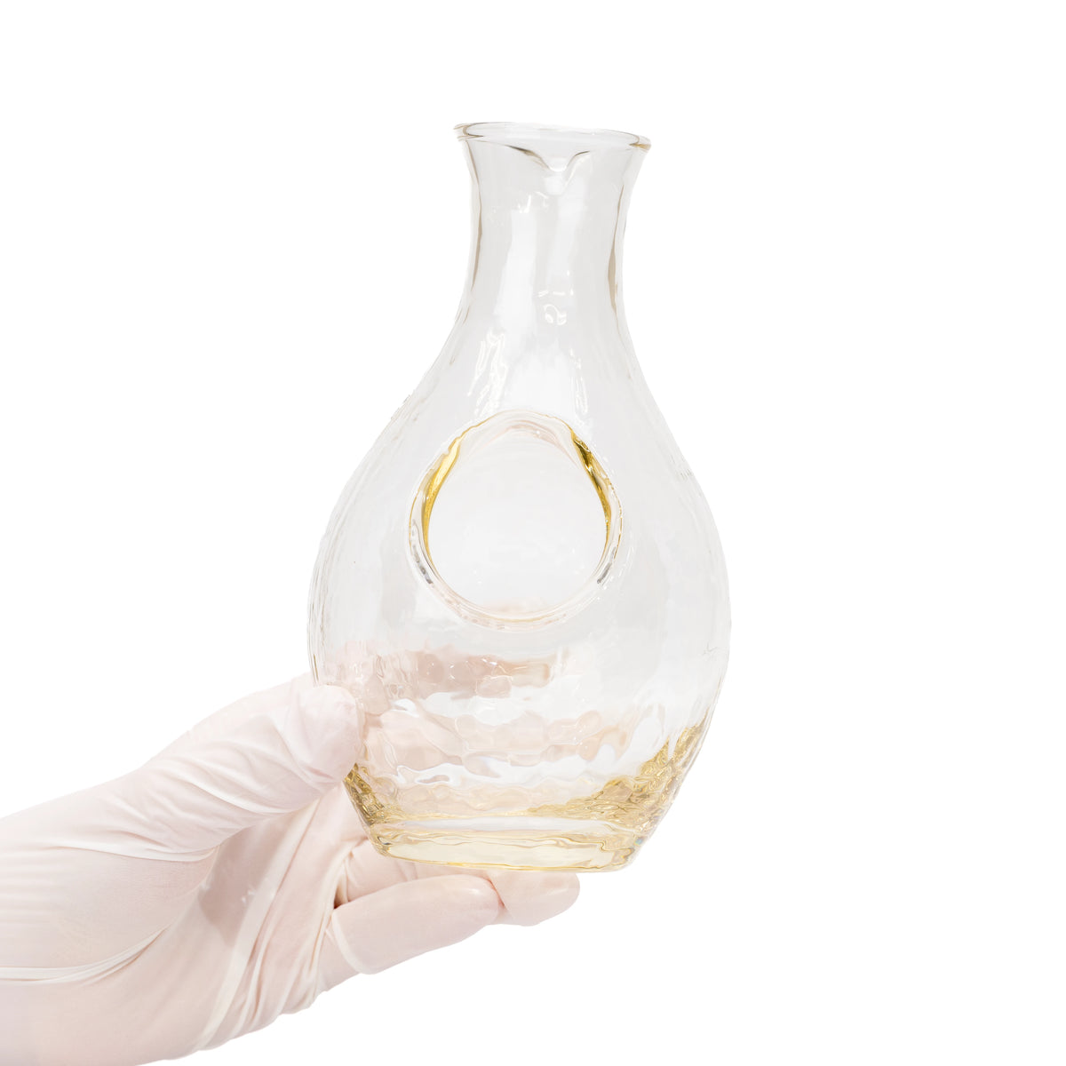 Glass sake carafe held in a gloved hand, showing its round ice pocket.