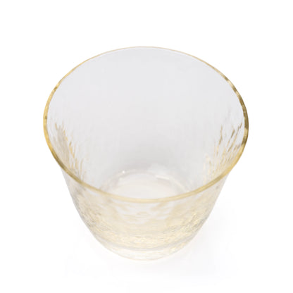 Overhead view into an amber-tinted glass sake cup.