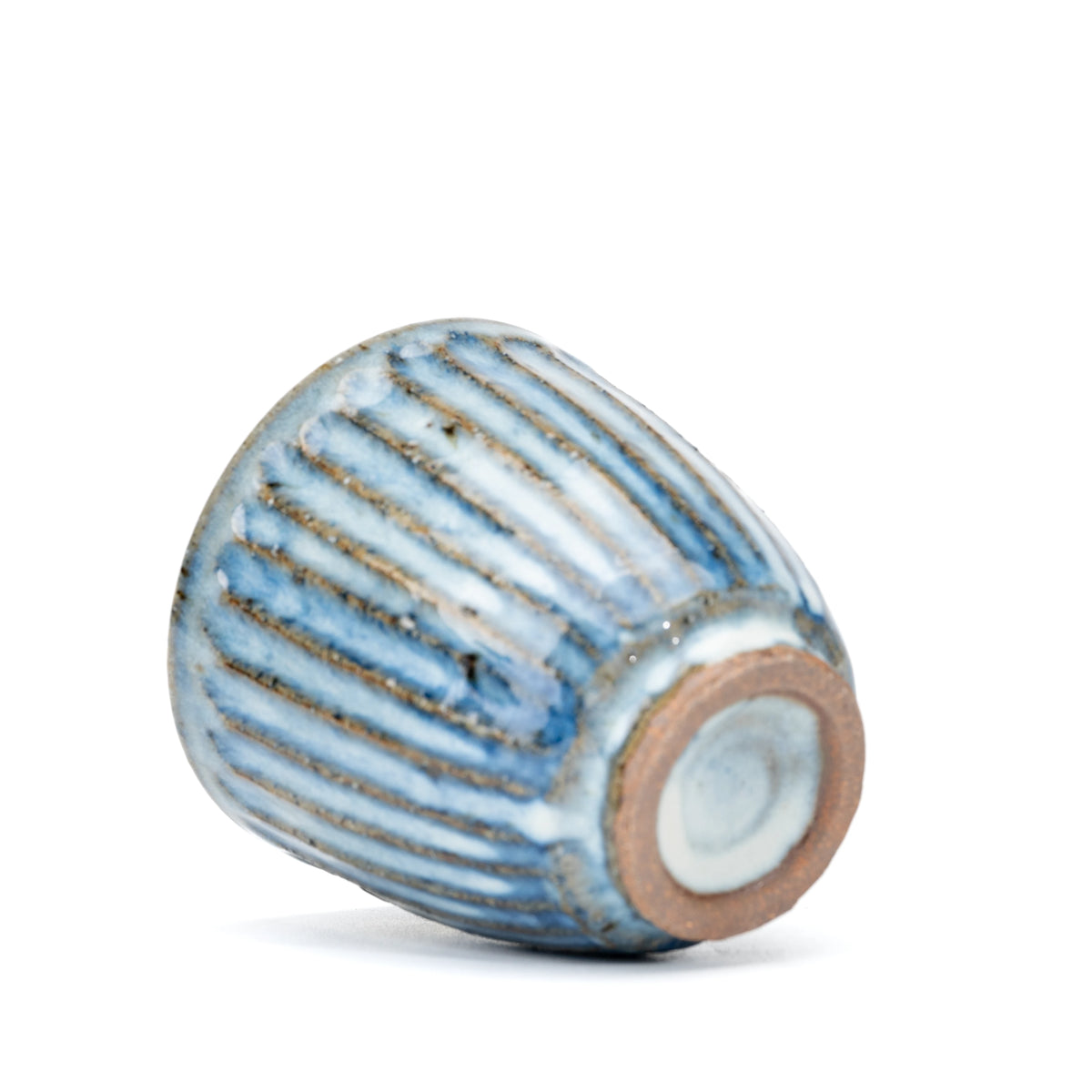 Ribbed yunomi tilted to show its circular unglazed foot.