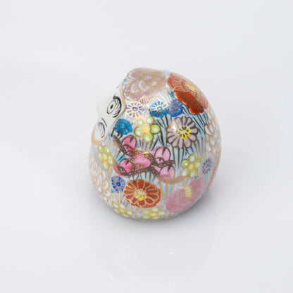 Left-side view of the blue Kutani Daruma, the floral pattern continuing around the porcelain body