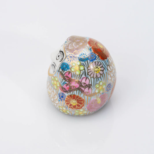 Left-side view of the blue Kutani Daruma, the floral pattern continuing around the porcelain body