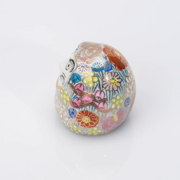 Left-side view of the blue Kutani Daruma, the floral pattern continuing around the porcelain body