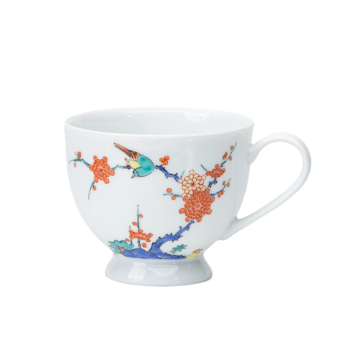 White porcelain cup with plum blossoms and a bird, viewed from the side.
