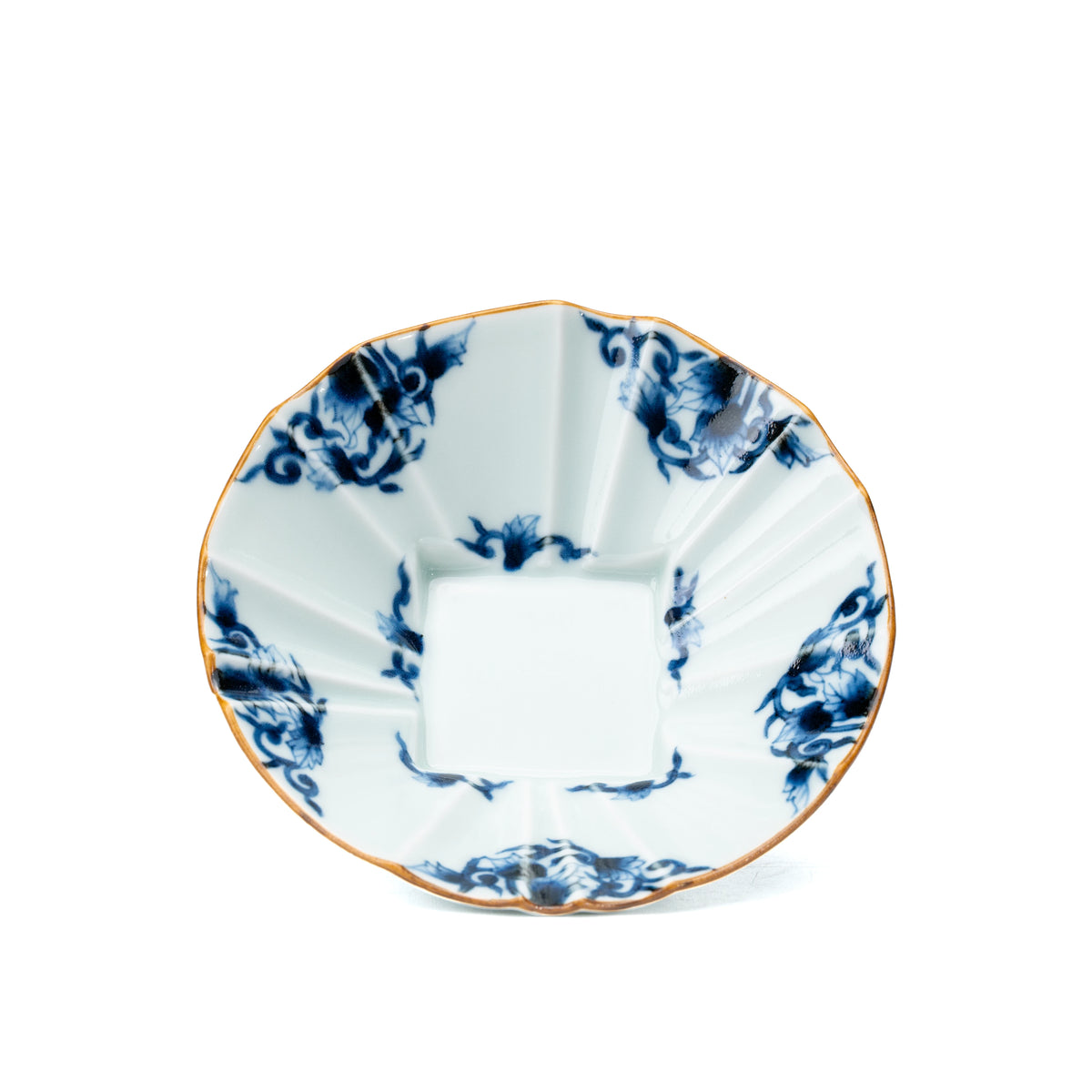 Overhead view of the bowl's blue arabesque decoration and white center.