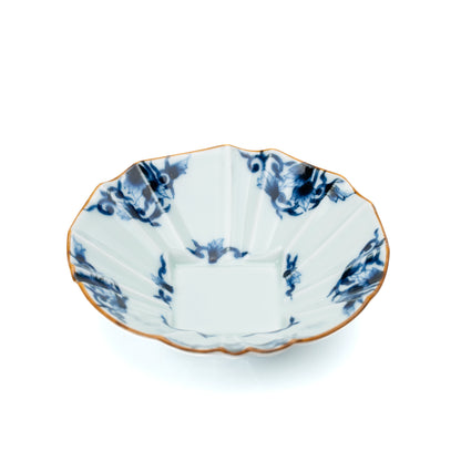 Blue and white porcelain bowl with a scalloped gold-edged rim and arabesque decoration on white.