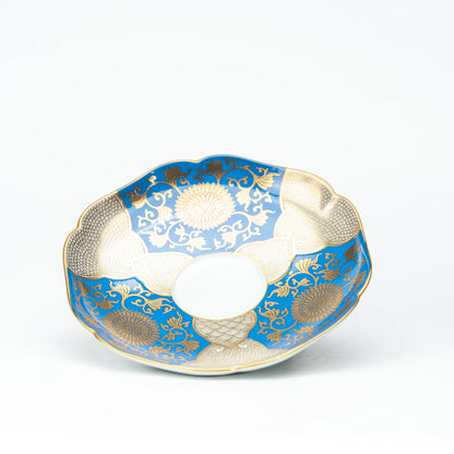 Blue and gold scalloped saucer viewed from above.