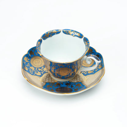 Blue and gold chrysanthemum cup and matching scalloped saucer on white.