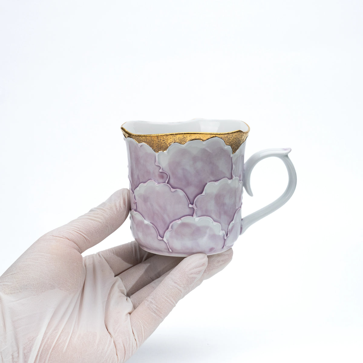 Purple peony mug held in a gloved hand.