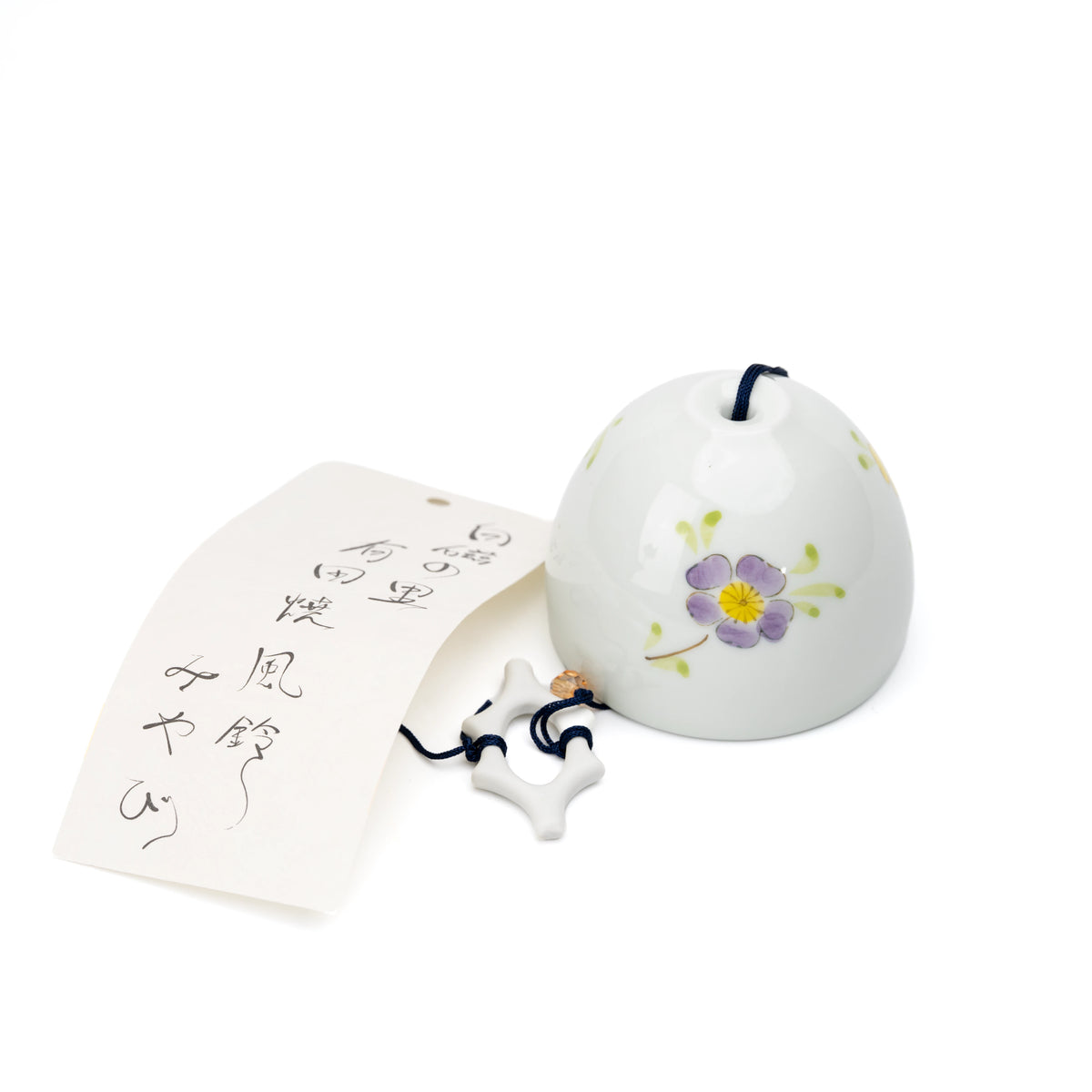 White porcelain wind chime with yellow and purple flowers and a paper strip on white.