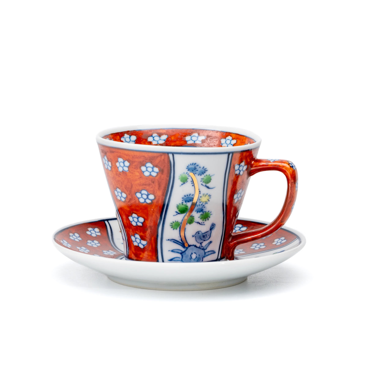 Red Arita cup and saucer with blue floral panels and small white flowers on white.