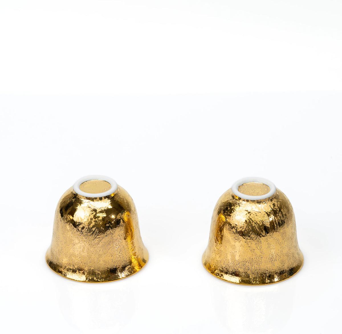 White foot rings on the undersides of the two gold cups.