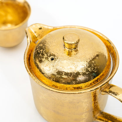 Overhead close-up of the gold teapot lid and knob.