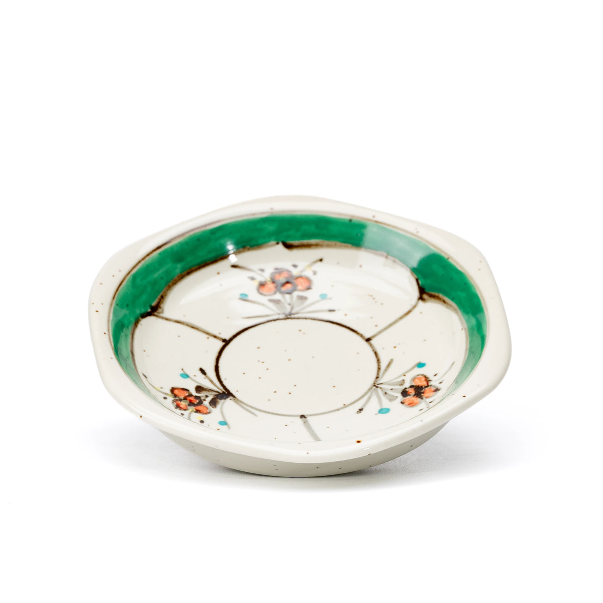 Hexagonal green-rimmed saucer with small floral decoration.