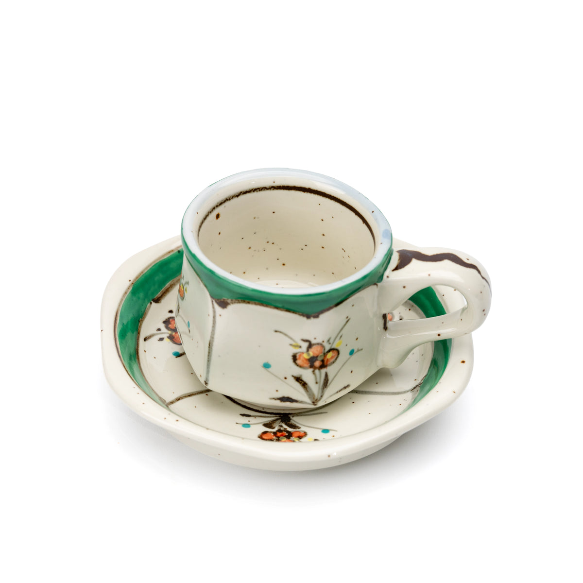 Angled top view of the green floral cup on its saucer.