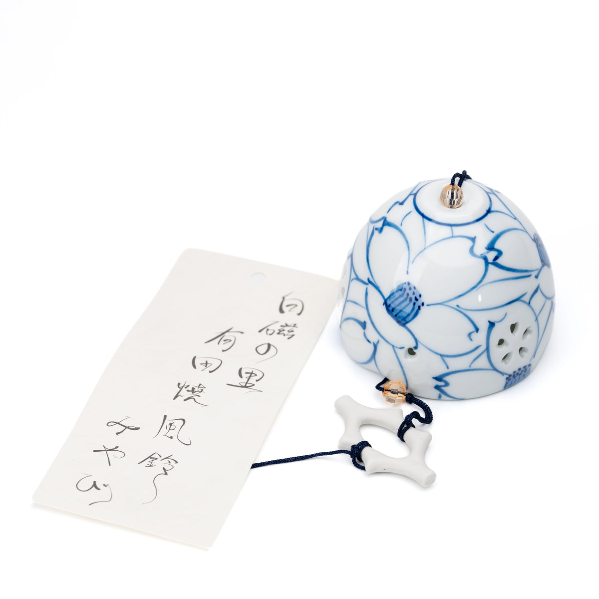 Blue and white porcelain wind chime with camellia outlines and a paper strip on white.