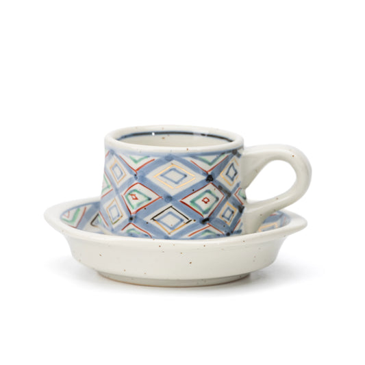 Hexagonal demitasse cup and saucer with blue, green and red diamond decoration on white.