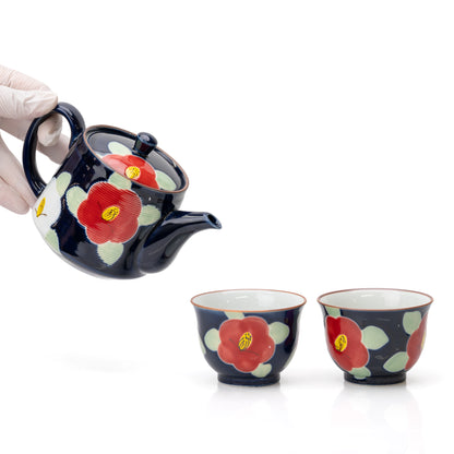 Blue camellia teapot held above the two matching cups.