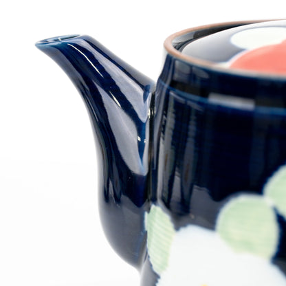 Close-up of the blue teapot's spout and white camellia.