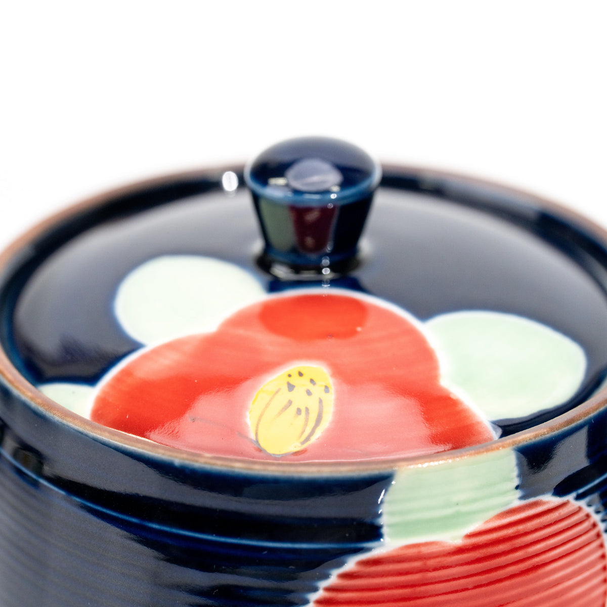 Close-up of the teapot lid with a red camellia.